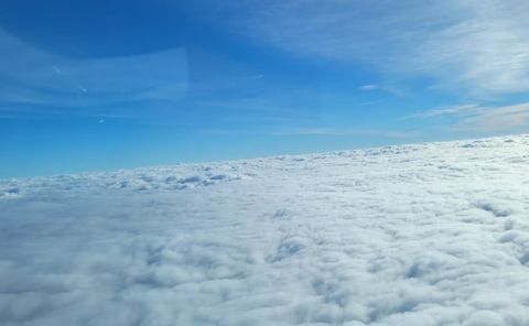 A flat, unbroken layer of cloud stretching to the horizon under a blue sky
